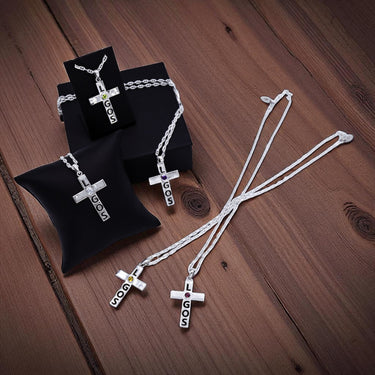 Silver cross necklaces with 'LOGOS' pendant on a wooden surface